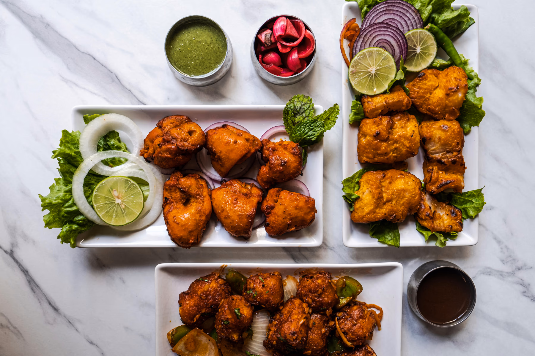 A generous chicken tikka platter with charred spices, onion and fresh lime